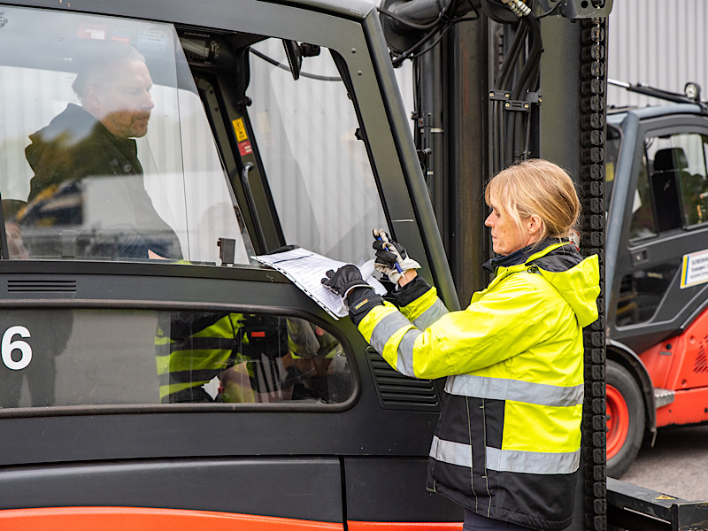 kvinna fyller i formulär vid truck