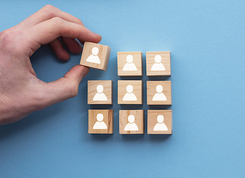 Hand adding a new team member to a group. Business management concept