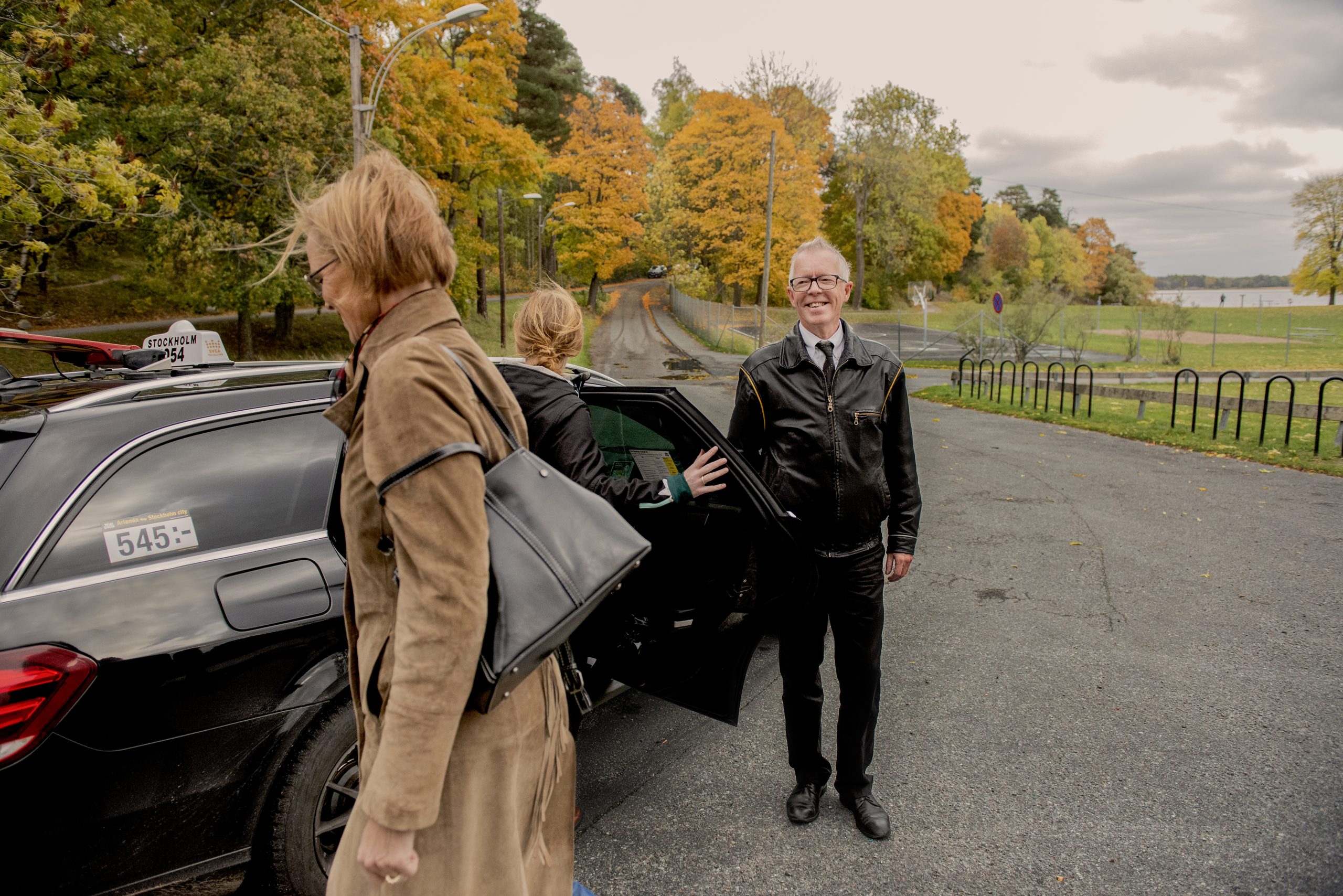 Taxiförare med kund utanför en bild.