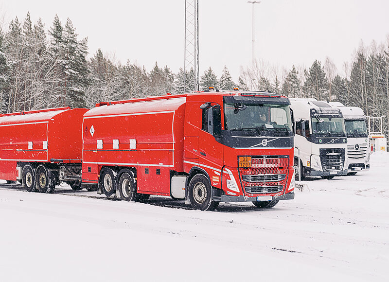 Lastbilar i snöigt vinterland.