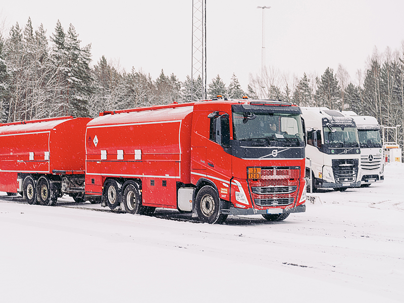 Lastbilar i snöigt vinterland.