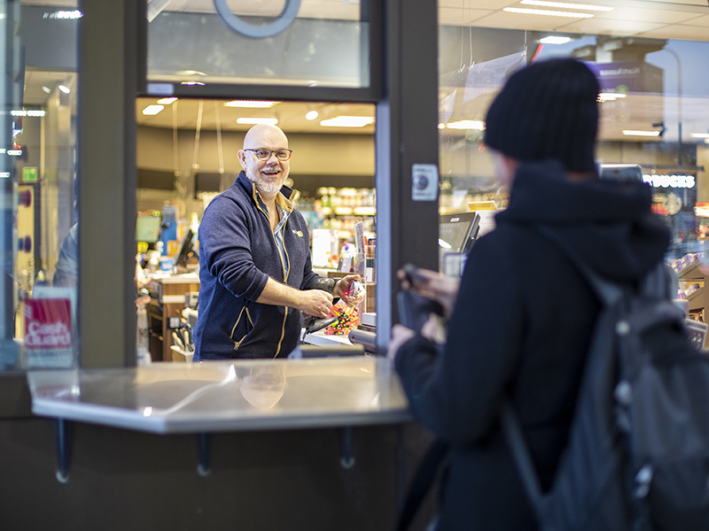 Man i lucka på bensinstation