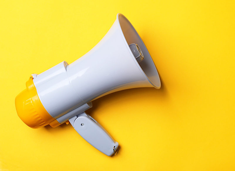 Electronic megaphone on color background