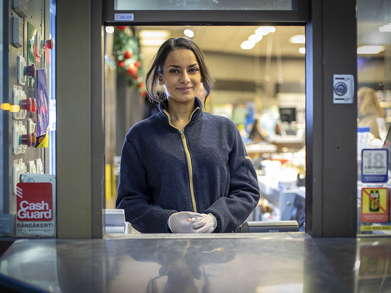 Ung kvinna i nattlucka på drivmedelsstation