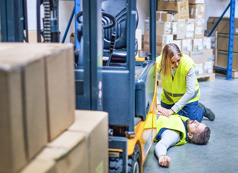 An accident in a warehouse. Woman performing cardiopulmonary resuscitation.